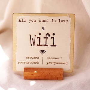 May include: A wooden sign with the text "All you need is love & wifi" and a wifi symbol. The sign also includes the network name "yournetwork" and the password "yourpassword".