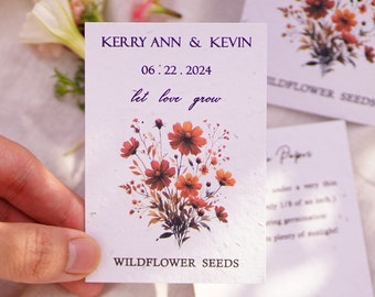 May include: A close-up of a wildflower seed packet with the names KERRY ANN & KEVIN and the date 06.22.2024 printed on it. The text "let love grow" is also visible. The packet features a floral design with orange and red flowers.