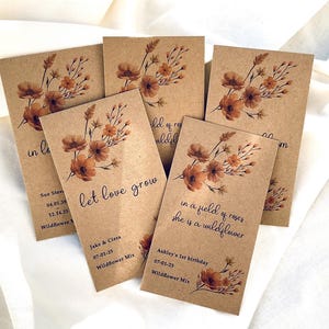 May include: Set of six brown paper seed packets with a floral design and text. The text on the packets includes "let love grow", "in a field of roses she is a wildflower", and dates.