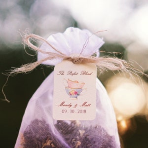 May include: A white organza bag tied with twine and a tag that reads "The Perfect Blend" with a watercolor illustration of two teacups and the text "Mandy & Matt 09.30.2018".