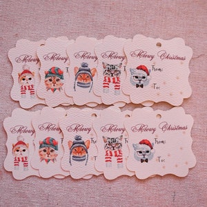 May include: A collection of cream-colored gift tags with scalloped edges. Each tag features a watercolor illustration of a cat wearing a hat and scarf. The tags are labeled "Meowy Christmas" with "From:" and "To:" fields.