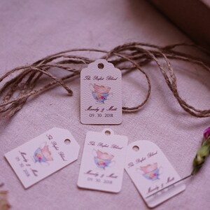 May include: Four white gift tags with a watercolor illustration of teacups and the text "The Perfect Blend" and "Mandy & Matt 09.30.2018". The tags are tied with twine.