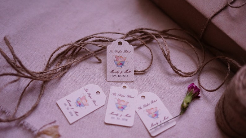 May include: Four white gift tags with a watercolor illustration of teacups and the text "The Perfect Blend" and "Mandy & Matt 09.30.2018". The tags are tied with twine.