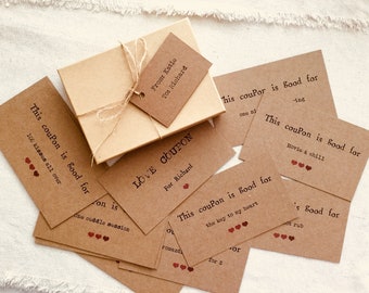 May include: A set of brown kraft paper cards with red hearts and the text "This coupon is good for" followed by different activities. The cards are tied together with twine and placed on a brown box with a tag that reads "From: Katio To: Richard".