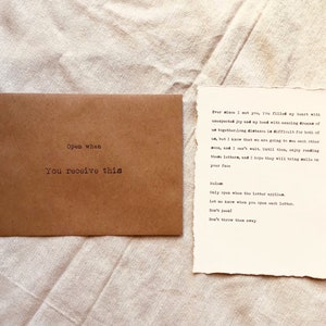 May include: A brown envelope with the text "Open when you receive this" printed on it. Next to the envelope is a piece of paper with the text "Ever since I met you, you filled my heart with unexpected joy and my head with amazing dreams of us together. Long distance is difficult for both of us, but I know that we are going to see each other soon, and I can't wait until then. Enjoy reading these letters, and I hope they will bring a smile on your face.  Salam. Only open when the letter applies. Let me know when you open each letter. Don't peek! Don't throw them away."