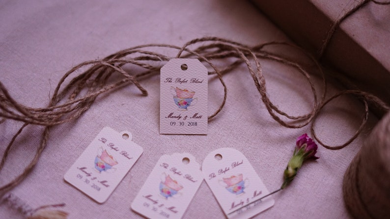 May include: Four beige gift tags with a brown twine string. Each tag has a watercolor illustration of a teacup and the text "The Perfect Blend" and "Mandy & Matt 09.30.2018".