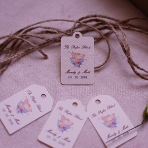 May include: Four cream-colored gift tags with a brown twine string. Each tag has a watercolor illustration of a teacup and saucer with the text "The Perfect Blend" and "Mandy & Matt" with the date "09.30.2018".