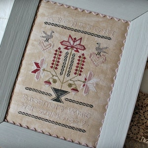 May include: A framed cross-stitch sampler with a floral design in shades of pink, red, and green. The sampler includes the text "Remember,  lay thine heart at His feet".