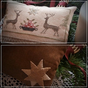 Peut inclure: Deux housses de coussin brodées sur le thème de Noël. Une housse de coussin est beige avec un motif de point de croix représentant deux rennes et une étoile. L'autre housse de coussin est marron avec une étoile en feutre appliquée.