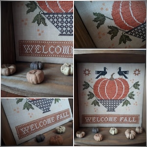 Könnte beinhalten: Ein gerahmtes Kreuzstich-Design mit einem Kürbis in einem Korb mit dem Text "Welcome Fall". Das Design ist von kleinen Kürbissen und Blättern umgeben.