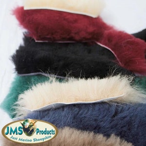 May include: Five different colors of sheepskin, including burgundy, black, green, blue, and natural. The sheepskin is shown with the fur side up and the leather side down. The sheepskin is a natural product and is perfect for a variety of uses, including upholstery, rugs, and clothing. The sheepskin is also very soft and comfortable.