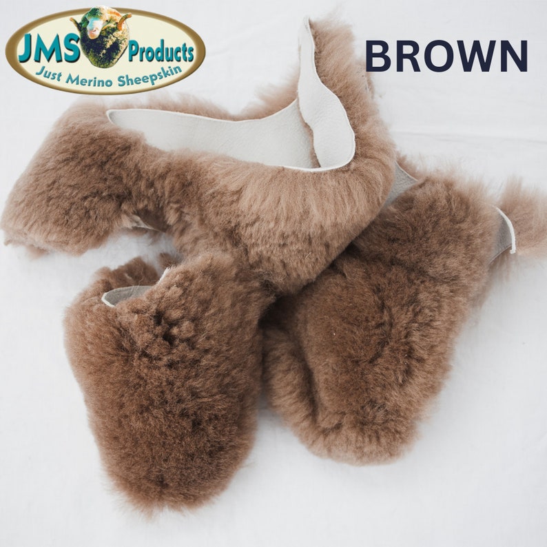 May include: A close-up of a brown sheepskin rug. The rug is made of soft, fluffy sheepskin and has a natural, rustic look. The rug is perfect for adding warmth and comfort to any room.