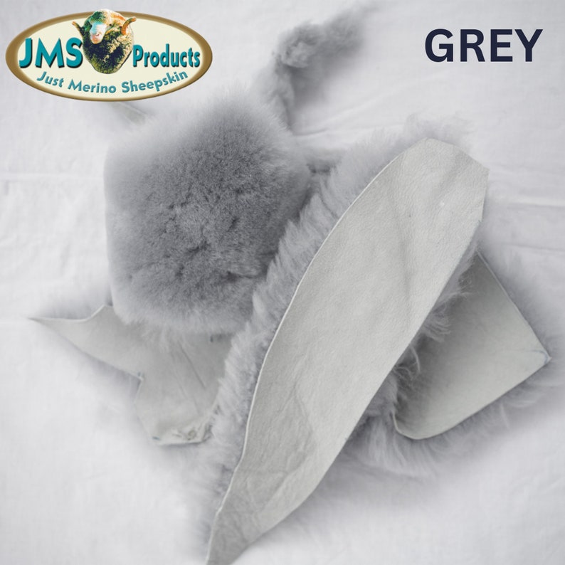 May include: A close-up of a grey sheepskin hide. The hide is folded in half, showing the fur on one side and the leather on the other. The text "GREY" is visible in the top right corner of the image.