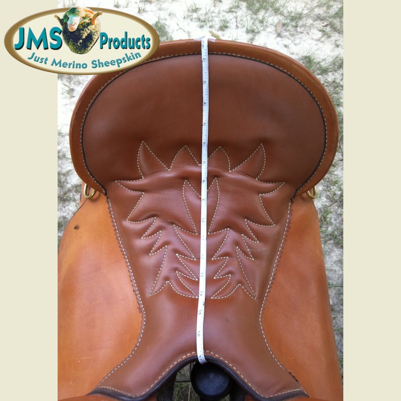May include: A brown leather saddle with a decorative stitching pattern. The saddle is 17 inches tall.