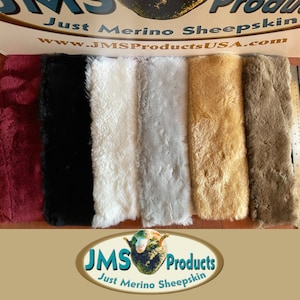 May include: A selection of merino sheepskin in various colors, including burgundy, black, white, gray, tan, and brown. The image displays the soft, textured wool with a ruler for scale. The logo "JMS Products Just Merino Sheepskin" is visible.