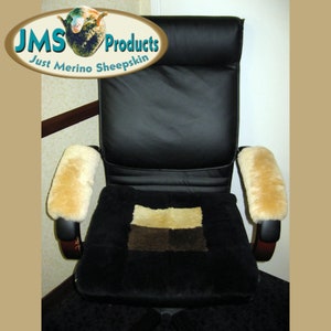 May include: A black office chair with a sheepskin seat cushion and armrests. The cushion is made of brown and beige sheepskin and has a checkered pattern. The armrests are also made of sheepskin and are a light brown color. The chair is in a room with a brown wall and a white wall.