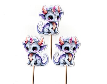 May include: Three purple and pink dragon cupcake toppers with a white background. The dragons have pink horns, wings, and tails. They are sitting on wooden sticks.