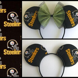 May include: Black and gold Pittsburgh Steelers themed mouse ears headband. The ears are black with the Steelers logo and text. A green bow sits between the ears. The headband is black.