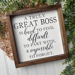May include: A white wooden sign with a brown frame, featuring the text "A truly great boss is hard to find, difficult to part with, & impossible to forget."