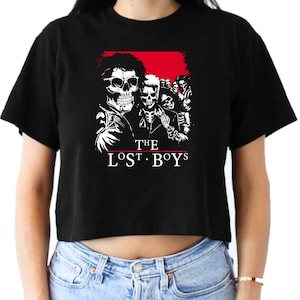 May include: Black cropped t-shirt with a white graphic of a group of skeletons with the text "THE LOST BOYS" underneath.