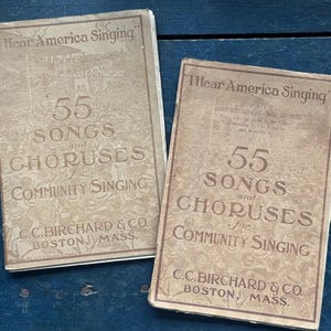 May include: Two vintage songbooks with the title "I Hear America Singing" and the text "55 Songs and Choruses for Community Singing". The books are published by C.C. Birchard & Co. Boston, Mass.
