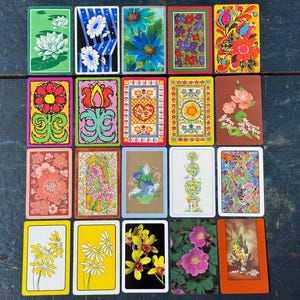 May include: A collection of twenty rectangular playing cards arranged in a grid, each featuring distinct floral, botanical, or decorative patterns in various colors including yellow, green, blue, red, and brown, with diverse artistic styles.