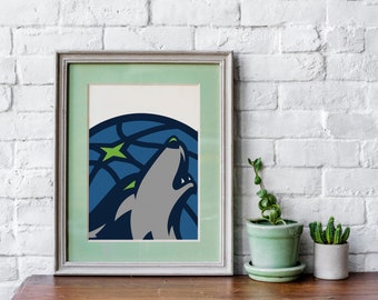 May include: A framed print of a stylized wolf howling at the moon. The wolf is gray and blue, and the moon is a blue and green geometric pattern. The frame is a light gray with a green mat.