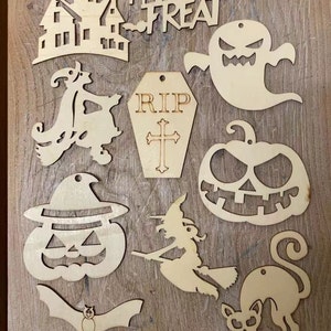 May include: A set of 10 wooden Halloween cutouts, including a haunted house, a ghost, a witch, a pumpkin, a bat, a spider, a cat, a coffin, a witch on a broomstick, and a pumpkin with a hat. The cutouts are all unpainted and ready to be decorated.