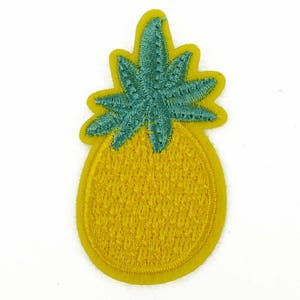 May include: A yellow pineapple with a green leafy top. The pineapple is embroidered with a textured pattern.