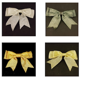 May include: Four decorative bows in a square grid. The bows are in shades of gold, silver, and green. Each bow has a textured, shimmering appearance. The bows are set against black and dark backgrounds.