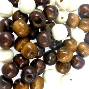 May include: A collection of wooden beads in brown, white and dark brown colours. The beads are round and have a smooth finish.