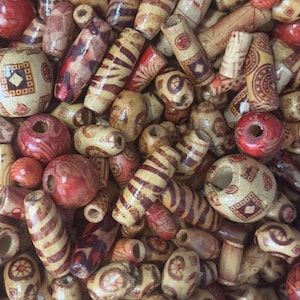 May include: A selection of wooden beads in assorted shapes and sizes. The beads are in natural wood tones with red and brown detailing. Some have striped patterns, others geometric designs. Ideal for crafting jewellery.