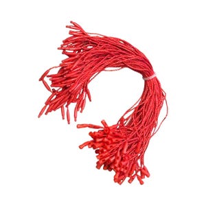 May include: A collection of bright red string tags, secured with a thin, clear elastic band. Each tag features a plastic fastener. The tags are arranged in a cascading, slightly curved shape against a white background.