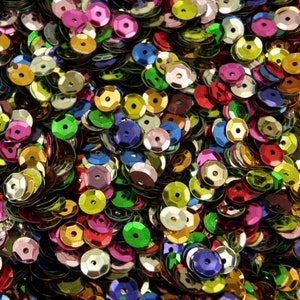 May include: A large assortment of colorful sequins in various shades of green, blue, red, gold, silver, and purple. The sequins are all the same size and shape, and they are arranged in a random pattern.