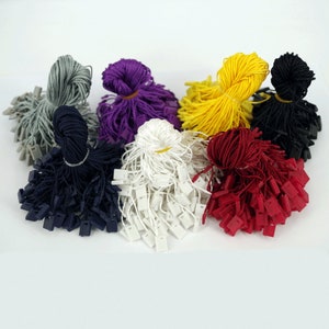 May include: Assortment of colourful string tags with plastic tips. The colours include grey, purple, yellow, black, white, red, and navy blue.