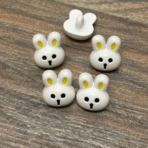 5 x shank buttons , white rabbit heads,  ideal for children's wear, knitting, sewing, even cards. new cute design