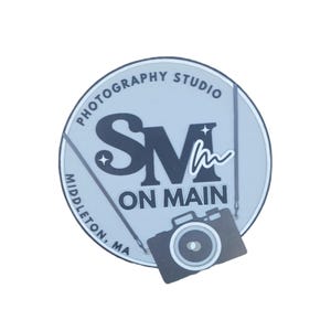 May include: A round, light blue logo with the text "PHOTOGRAPHY STUDIO" and "MIDDLETON, MA" encircling the top and bottom. The center features "SM ON MAIN" and a camera graphic.