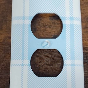 May include: A light blue and white plaid outlet cover plate.