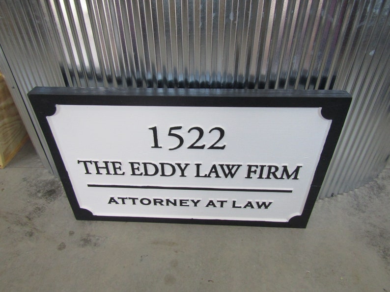 Puede incluir: Un letrero en blanco y negro con el texto "1522 THE EDDY LAW FIRM ATTORNEY AT LAW".