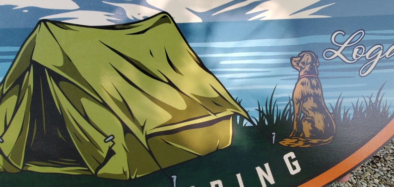 May include: A green camping tent with a brown dog sitting in the grass next to a lake. The text "Log Cabin" is written in cursive on the sign.