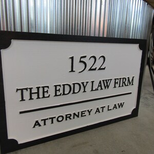 Puede incluir: Un letrero en blanco y negro con el texto "1522 The Eddy Law Firm Attorney at Law".