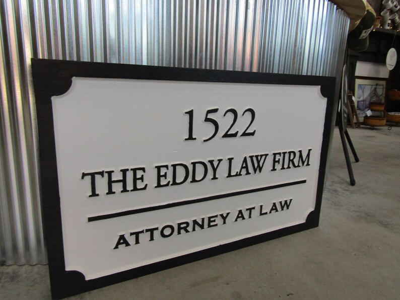 Puede incluir: Un letrero en blanco y negro con el texto "1522 The Eddy Law Firm Attorney at Law".