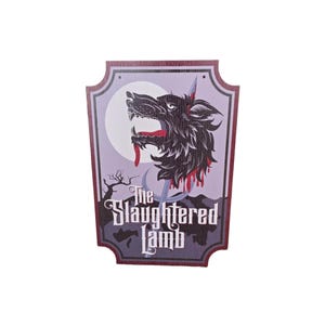 May include: A decorative sign with a wolf illustration and the text "The Slaughtered Lamb." The sign features a wolf with red accents, a full moon, and a spooky tree. The sign has a dark purple and gray color scheme.