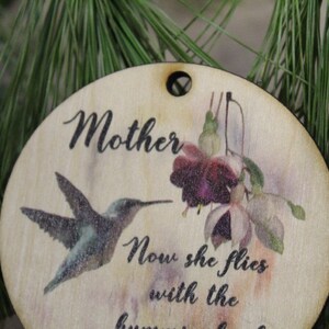 May include: Wooden ornament with a hummingbird and flowers, and the text "Mother Now she flies with the hummingbirds".