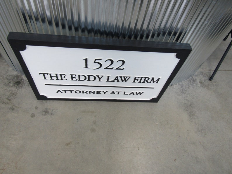 Puede incluir: Un letrero en blanco y negro con el texto "1522 The Eddy Law Firm Attorney at Law".