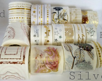 May include: A collection of decorative washi tapes with gold and silver foil accents. The tapes feature various designs, including stars, geometric patterns, and floral motifs. The text "Gold and Foil" appears on the left side of the image, and "Silver" appears on the right side.