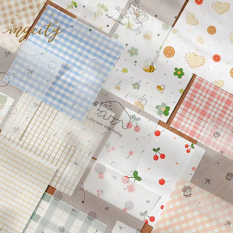 May include: A set of 15 transparent decorative sheets with various patterns, including checkered, polka dot, floral, and animal designs. The sheets are printed with light blue, pink, and white colors. The text "mycity" and "Angels can magic" are visible on the sheets.