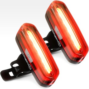 May include: Two red bike tail lights with a black mount and a white button. The lights are rectangular and have a bright white LED light inside.
