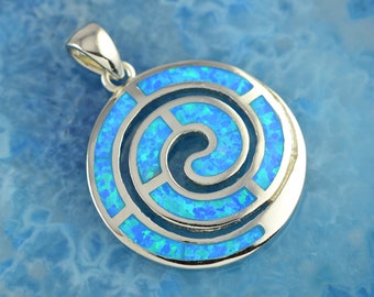 Könnte beinhalten: Ein silberner Anhänger mit einem blauen Opal-Inlay in Form einer Spirale. Der Anhänger liegt auf einem blauen Hintergrund.