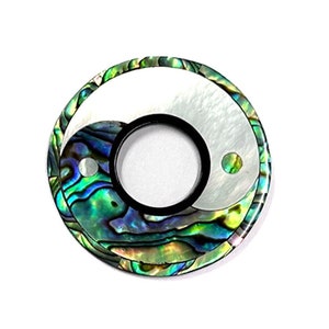 Może przedstawiać: Okrągła, czarno-biała płytka przełącznika z zielonym, niebieskim i białym wzorem z muszli abalone. Płytka jest do gitary Les Paul.